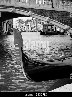 Venezianische Gondel und die Rialtobrücke, Venedig, Italien. Detail der prow Dekoration einer traditionellen Gondel auf dem Grand Canal. Stockfoto