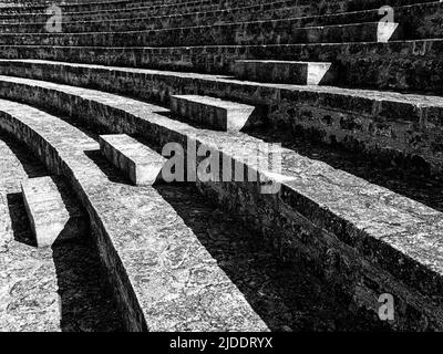 Steinsitze im antiken römischen Amphitheater in Arles werden noch heute für Aufführungen genutzt. In schwarz und weiß. Stockfoto