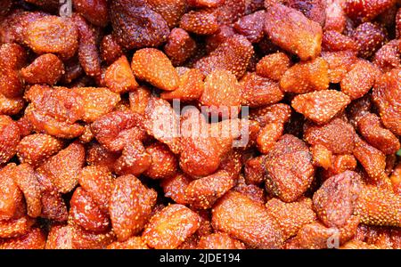 Getrocknete Erdbeerstücke in hellrotem Zucker Stockfoto