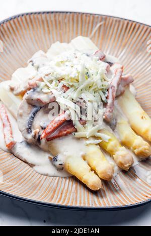 Weißer Aparagus mit Pilzsauce und Schinken, serviert mit Blauschimmelkäse Stockfoto