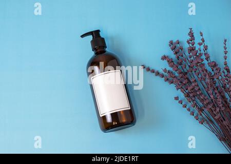 Leere bernsteinfarbene Glasseife oder Shampoo-Flasche auf isoliertem Hintergrund. Hautpflege oder Haarkonzept mit Naturkosmetik. Stockfoto