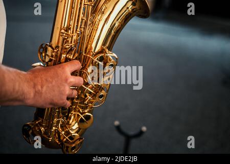 Ein Saxophonist, der einen goldenen Tenorsax spielt Stockfoto