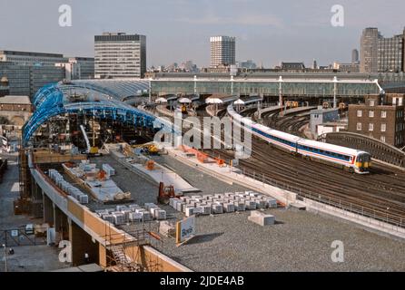 A Network Southeast Class 442 Wessex Electric verlässt London Waterloo und besteht die laufenden Bauarbeiten für die vier neuen Plattformen, um die bald eingeführten Eurostar-Züge unterzubringen. Nach der Fertigstellung würden diese neuen Bahnsteige den Bahnhof Waterloo International bilden, der am 14.. November 1994 eröffnet wurde. 28.. Juli 1992. Stockfoto