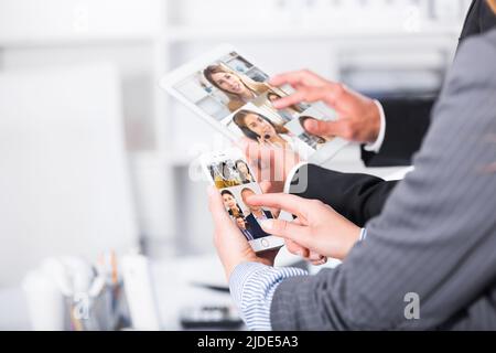 Hände von Geschäftspartnern, die Geräte verwenden Stockfoto