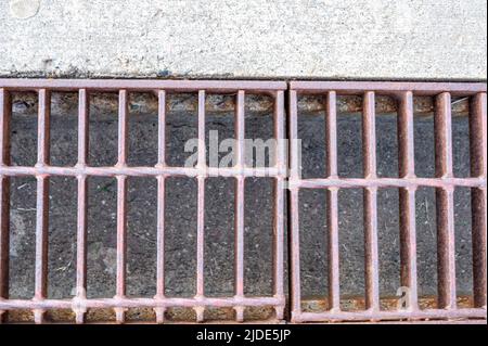 Rost über einem Regenwassergruben in einer Betonplatte. Stockfoto