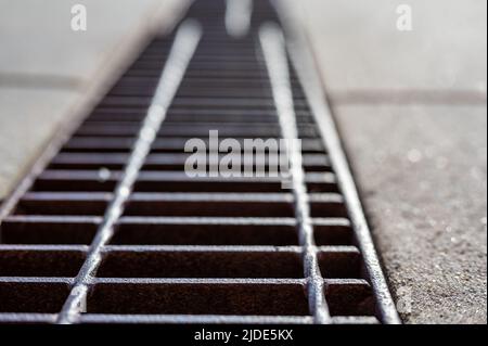 Rost über einem Regenwassergruben in einer Betonplatte. Stockfoto