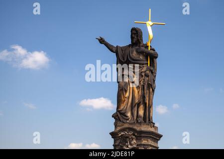 Die Statue des heiligen Johannes des Täufers an der Karlsbrücke steht tagsüber unter blauem Himmel. Prag, Tschechische Republik Stockfoto