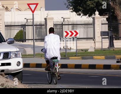 Sharjah, VAE 21. Februar 2020: Ein Mann in Nationaltracht fährt mit dem Fahrrad. Stockfoto