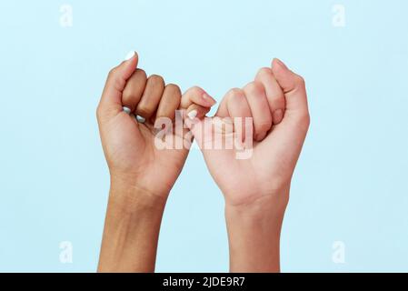 Stoppen Sie Rassismus. Afrikanische und kaukasische Hände gestikulieren auf blauem Studiohintergrund. Toleranz und Gleichheit, Einheitskonzept. Weltweite multirassische Gemeinschaft Stockfoto