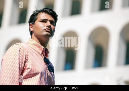 Schöner, stylischer Mann im Freien mit gestreiftem Hemd. Sonnenbrille nicht getragen. Gebäude im Hintergrund. Stockfoto