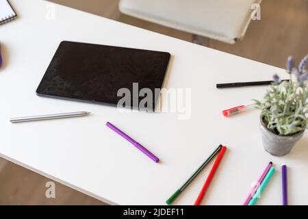 Tablet auf Holzschreibtisch mit Bleistift und Stift Stockfoto