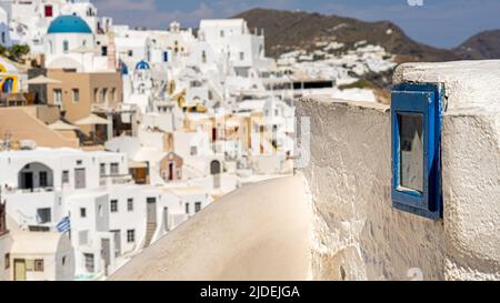 Eine alte Gebetsnische in Oia mit der Stadt im Hintergrund in einer Panoramaaufnahme mit einem flachen Fokus Stockfoto