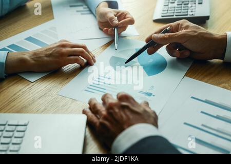 Geschäftsleute diskutieren die Geschäftsmarketingstrategie und analysieren die Berichtdiagramme am Schreibtisch Stockfoto