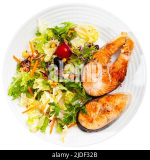 Lachssteak mit Petersilie, Mais, Salat, Karottensalat Stockfoto