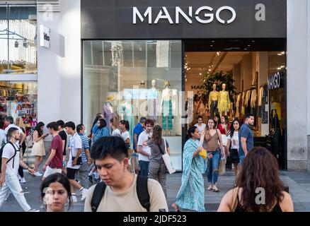 Fußgänger laufen am spanischen Mango-Laden der multinationalen Bekleidungsmarke vorbei. Stockfoto