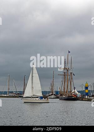 Eckernförde, Schleswig-Holstein, Deutschland - 29. august 2021: Segelschiffe und Leuchtturm im Hafen von Eckernförde unter bewölktem Himmel, Schleswig-Holstein, Ge Stockfoto