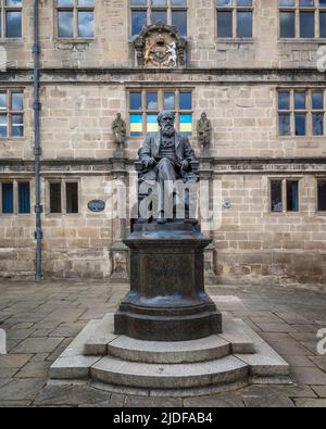 Eine Bronzestatue von Charles Darwin vor der Shrewsbury-Bibliothek. Das Gebäude war früher Shrewsbury School, die Darwin besuchte als Junge. Stockfoto