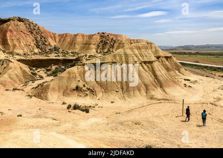 Zwei Wanderer wandern in der Wüste der Bardenas Reales, unter der Frühlingssonne. Bardenas Reales, 30. April 2022. Stockfoto