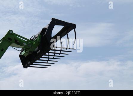 Ein landwirtschaftliches Gras greifen auf einem langen Hydraulikarm. Stockfoto