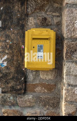 Gelber Briefkasten auf einer Straße in den französischen Pyrenäen Stockfoto