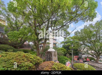 nagasaki, kyushu - 11 2021. dezember: Gedenkstatue für Atombomben eines 'Kindes, das für den Frieden betet', umgeben von farbenfrohen Dekorationen, die Tausend genannt werden Stockfoto