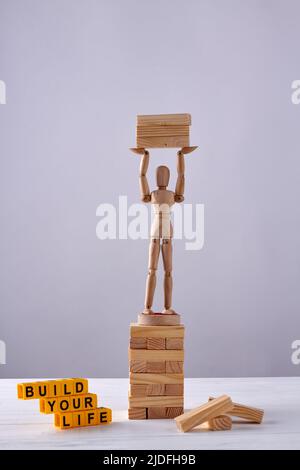 Vertikale Aufnahme von hölzernen Schaufensterpuppe mit Holzblöcken. Entwickeln Sie Ihr Lebenskonzept. Stockfoto