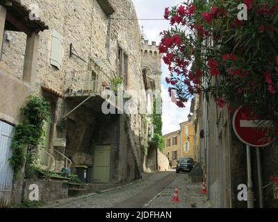 Folgen Sie einem historischen Pfad durch die engen, gewundenen Straßen mit hohen Gebäuden in der malerischen Altstadt von Viviers, Frankreichs kleinster Stadt. Stockfoto