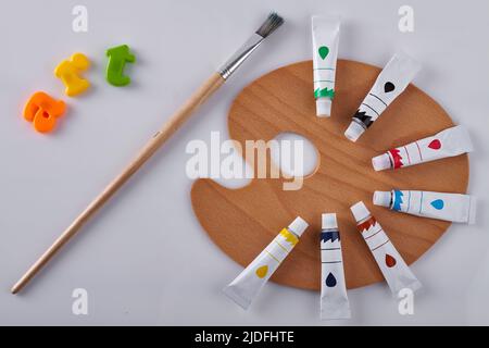 Reinigen Sie die Holzpalette mit einem Pinsel auf weißem Hintergrund. Ölrohre im Kreis. Farbenfrohe Wortkunst Stockfoto