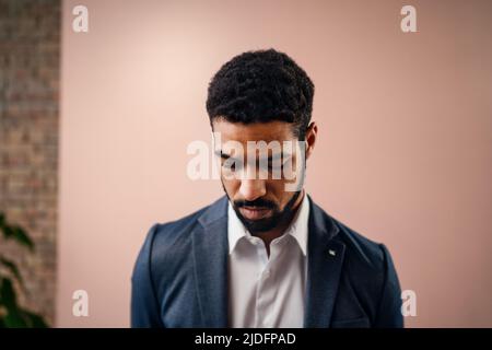 Seriöse junge Geschäftsmann schaut weg, Studio geschossen. Stockfoto