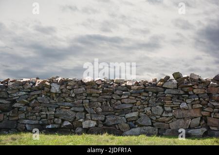 muro de piedra con cielo nublado gris Stockfoto