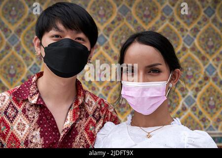 Japanischer Mann mit seinem transsexuellen Paar, das Gesichtsmaske im Freien trägt Stockfoto