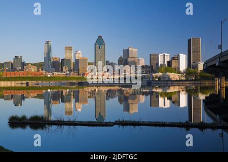 Die Skyline von Montreal spiegelt sich im Peel Basin bei Sonnenaufgang in Quebec, Kanada. Stockfoto