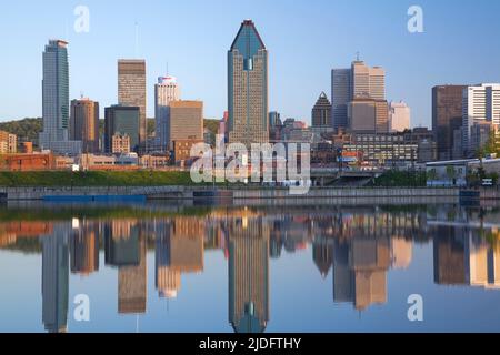 Die Skyline von Montreal spiegelt sich im Peel Basin bei Sonnenaufgang in Quebec, Kanada. Stockfoto