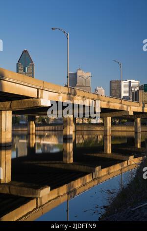 Die Skyline von Montreal und die erhöhte Autoroute spiegeln sich im Peel Basin bei Sonnenaufgang, Quebec, Kanada. Stockfoto