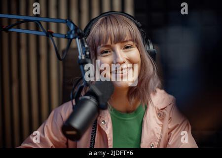 Porträt einer Sprecherin im Radio, die während der Moderation einer Live-Show im Mikrofon spricht Stockfoto