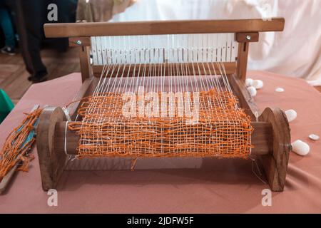 Antique Stoff Webmaschine mit kleinen Kokons auf der Seite. Stockfoto