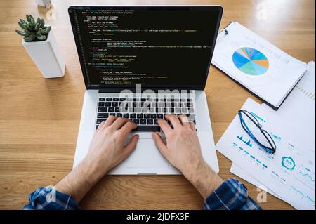 Softwarekonzept. Draufsicht der männlichen Hände auf Laptop-Tastatur, IT-Spezialist, Programmierer, verwendet Laptop, Code eingeben, Arbeiten an der Entwicklung einer Website, Anwendung, Schreiben von Codes und Datencode Stockfoto