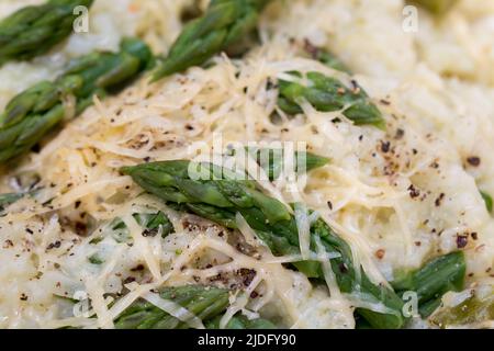 Italienisches Risotto mit Frühlingsspargel und geriebenem Käse in Teller Nahaufnahme selektiver Fokus Stockfoto