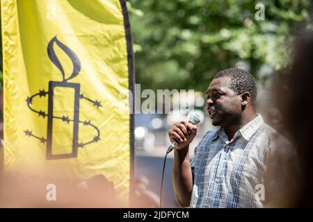 Mamadou KonatÈ, ein Flüchtling aus der Elfenbeinküste, der in vier Haftanstalten in Quebec festgehalten wurde und seine Asylanträge während des Protestes abgelehnt hatte, spricht. An diesem Weltflüchtlingstag organisierte Amnesty International Canada in Zusammenarbeit mit Human Rights Watch einen Protest vor dem Büro des Premierministers Ministerís in Montreal, um das Ende der eingeleiteten Haft von Flüchtlingen und Asylbewerbern in Quebec zu fordern. Die Kampagne mit dem Namen #BienvenueAuCanada suchte nach Unterschriften von Quebecís-Politikern, um Verträge mit Provinzgefängnissen zu beenden, die Migranten aufnehmen. Stockfoto