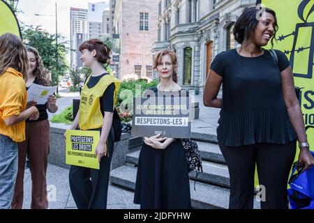 Montreal, Kanada. 20.. Juni 2022. Demonstranten halten Plakate zur Unterstützung der Menschenrechte während des Protestes. An diesem Weltflüchtlingstag organisierte Amnesty International Canada in Zusammenarbeit mit Human Rights Watch einen Protest vor dem Büro des Premierministers Ministerís in Montreal, um das Ende der eingeleiteten Haft von Flüchtlingen und Asylbewerbern in Quebec zu fordern. Die Kampagne mit dem Namen #BienvenueAuCanada suchte nach Unterschriften von Quebecís-Politikern, um Verträge mit Provinzgefängnissen zu beenden, die Migranten aufnehmen. (Foto: Giordanno Brumas/SOPA Images/Sipa USA) Quelle: SIPA USA/Alamy Live News Stockfoto