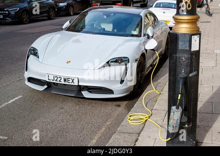 Elektrischer Porsche Motor Car wird von Lampenpfosten in London, England, Großbritannien, Samstag, 21. Mai, geladen 2022. Stockfoto