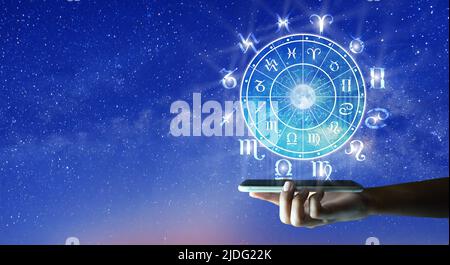 Astrologische Tierkreiszeichen innerhalb des Horoskopkreises auf Mobiltechnologie. Astrologie, Kenntnis der Sterne am Himmel über der Milchstraße und dem Mond. Stockfoto