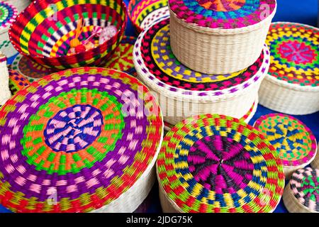 Auf dem Kunsthandwerksmarkt in Cuenca, Ecuador, werden Korbkörbe aus Toquilla-Stroh, Pflanzenfasern und verschiedenen Farben bemalt Stockfoto