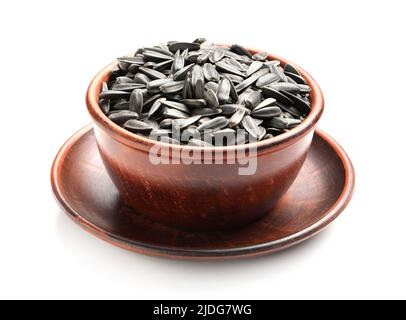 Ungeschälte Sonnenblumenkerne in einer Schüssel auf weißem Hintergrund Stockfoto