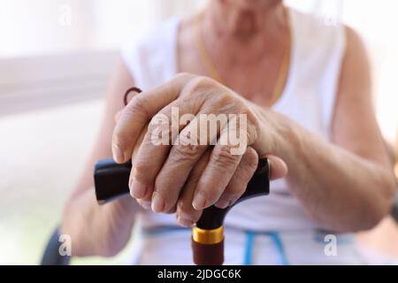Hände einer alten Frau mit Gehstock Stockfoto