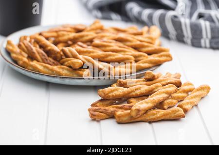 Gesalzene Brezelstangen. Gesalzene Cracker auf einem Teller. Stockfoto