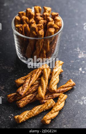 Gesalzene Brezelstangen. Gesalzene Cracker auf einem schwarzen Tisch. Stockfoto