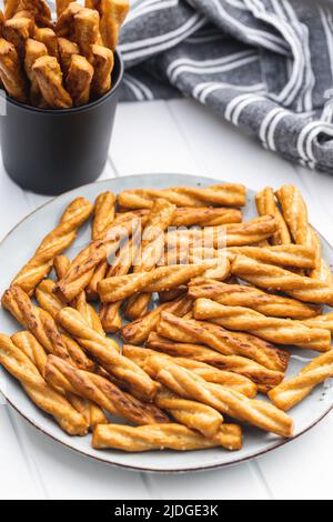 Gesalzene Brezelstangen. Gesalzene Cracker auf einem Teller. Stockfoto