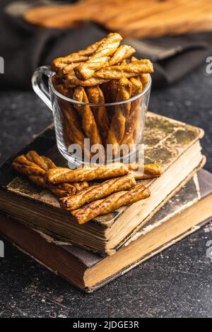 Gesalzene Brezelstangen. Gesalzene Cracker auf einem schwarzen Tisch. Stockfoto