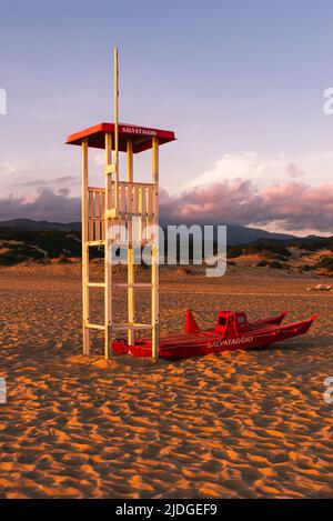 Salvataggio Rettungsschwimmer Wachturm und Rettungsboot am Sandstrand von Piscinas im goldenen Licht bei Sonnenuntergang, Costa Verde, Sardinien, Italien Stockfoto